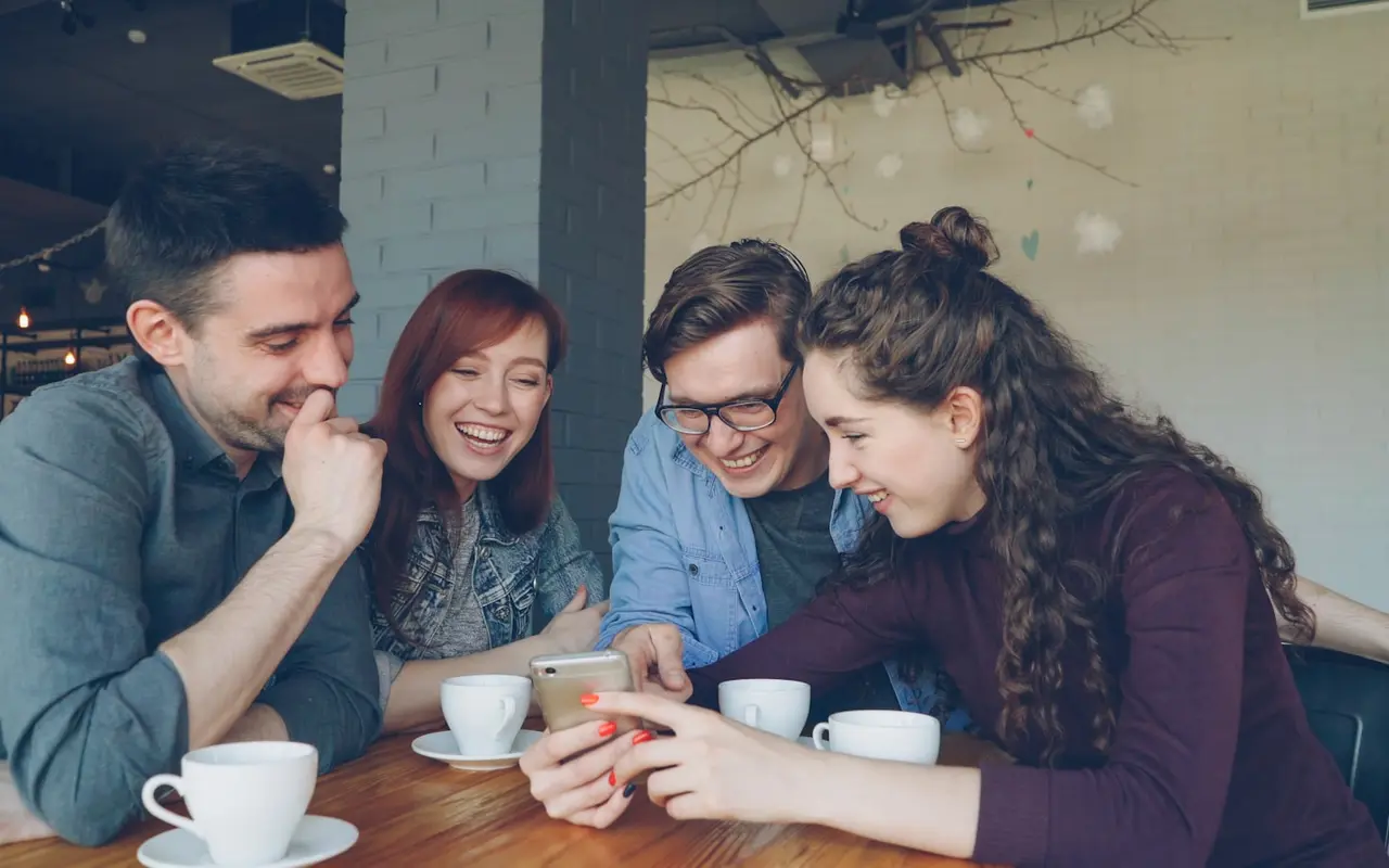 A small group of students collaborating around a laptop on a group project