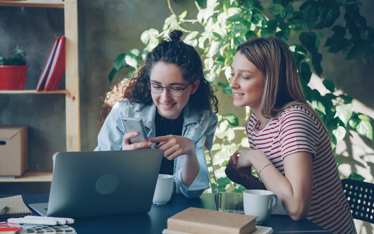 A student reviewing a business plan on a laptop at a co-working desk