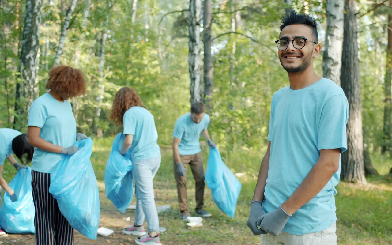 Volunteers smiling together during a forest cleanup