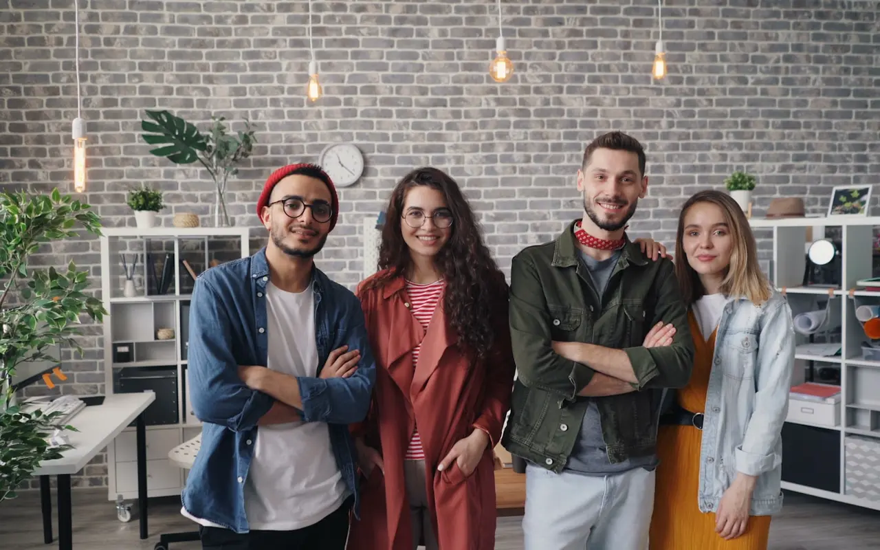 Four colleagues in conversation in a brick-loft office