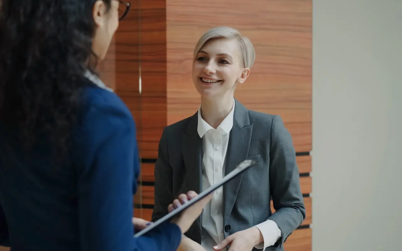 Two colleagues in conversation against a wood-panel backdrop