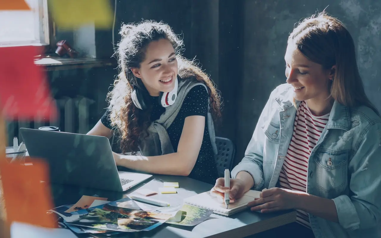 Two colleagues planning and sketching at a sunlit desk