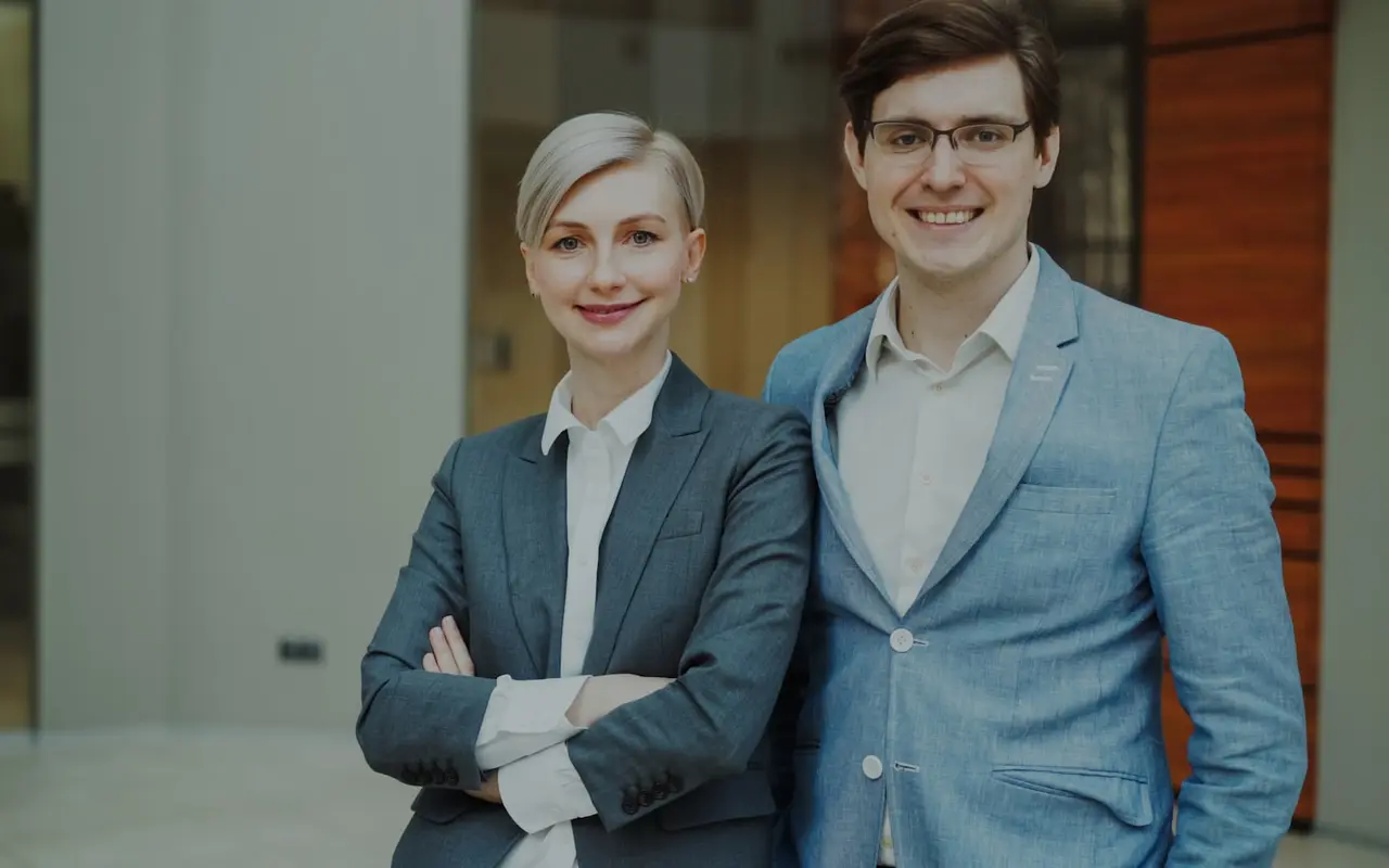 Two professionals standing together in a modern office lobby