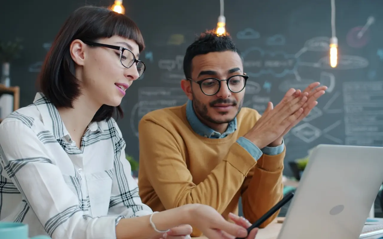 A mentor explaining an idea to a colleague who is listening closely
